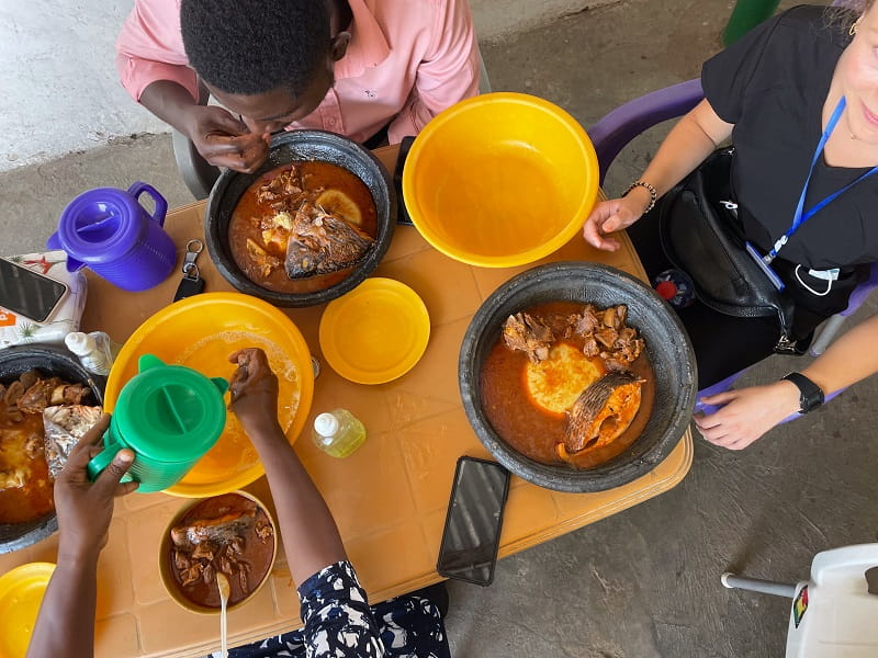 Shelby Cobb takes photos of a table of food in Ghana.