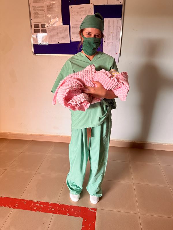 Melisa Davis posing with a child during a 2025 global health trip to Uganda.