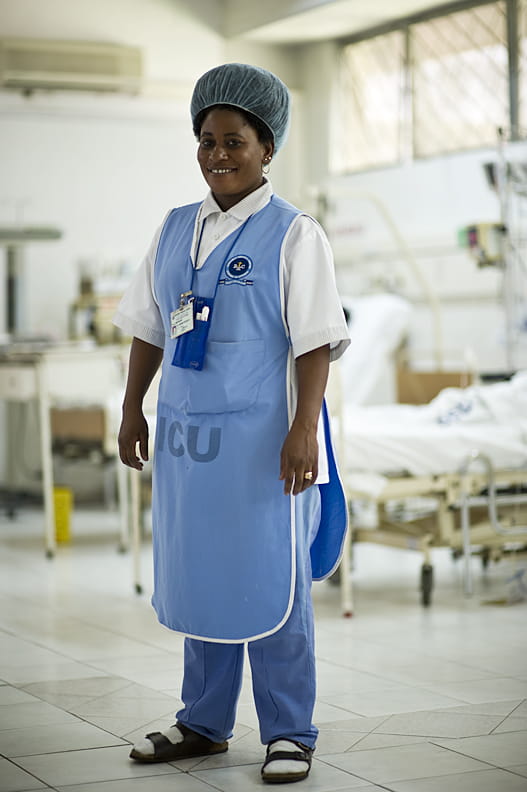 A nurse poses for a photo in a hospital.