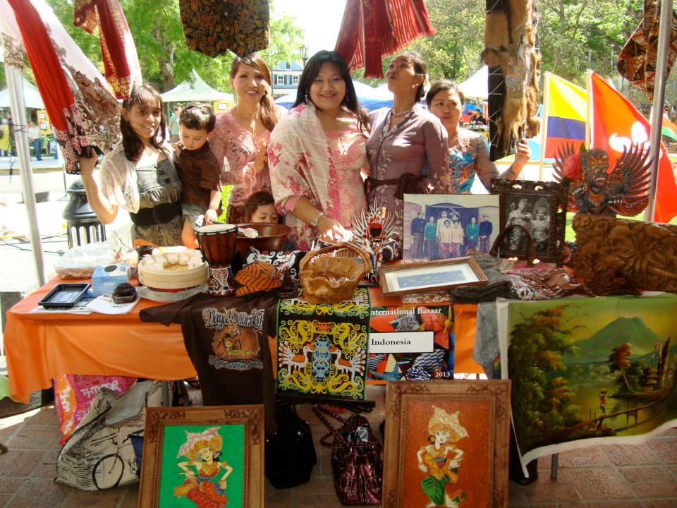 A group of women and children at an International Bazaar art booth.