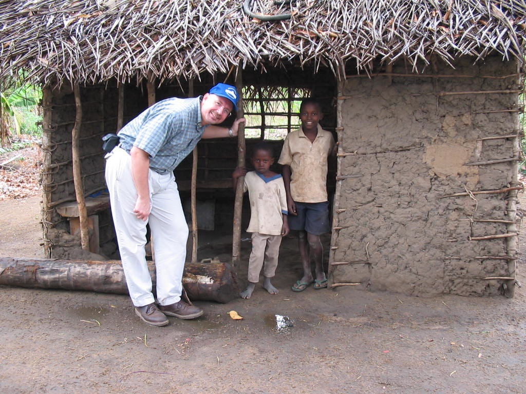 Dr. Sweat in Tanzania poses for a photo with village children while studying HIV/Aids prevention and treatment.
