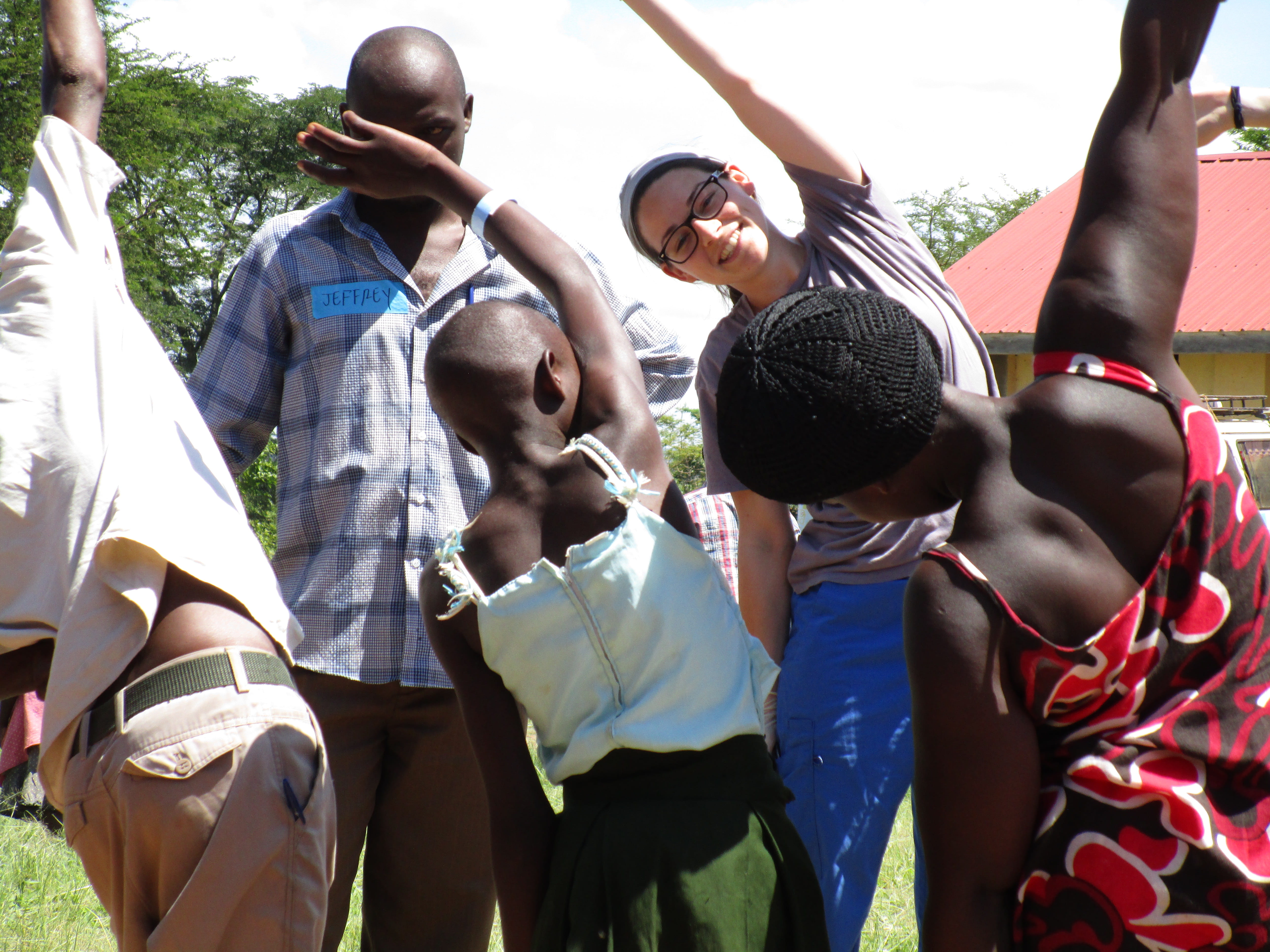 Medical student and children stretch in Uganda