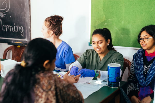 Nursing students assist a patient in India.
