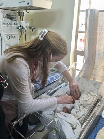 Charlotte Stegall works with a patient in the NICU in Tanzania.