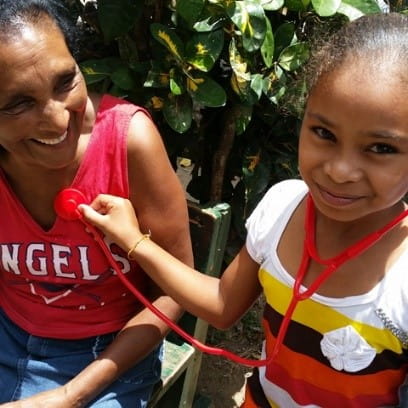 A child checks the heartbeat of a woman in Honduras.