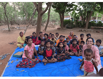 A group of children in India sit in a group.