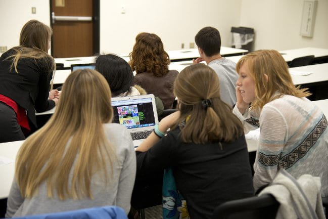 Students sitting around a laptop