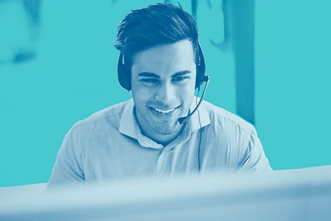  Smiling man with headset looking at computer screen