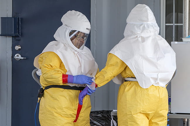 Two healthcare workers wearing PPE at COVID-19 specimen collection site