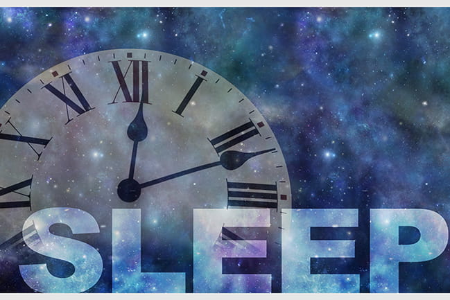 SLEEP typed over photo of analog clock against a starry night sky