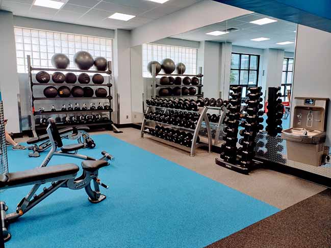 View of side weight room containing weights, exercise balls, and a fountain