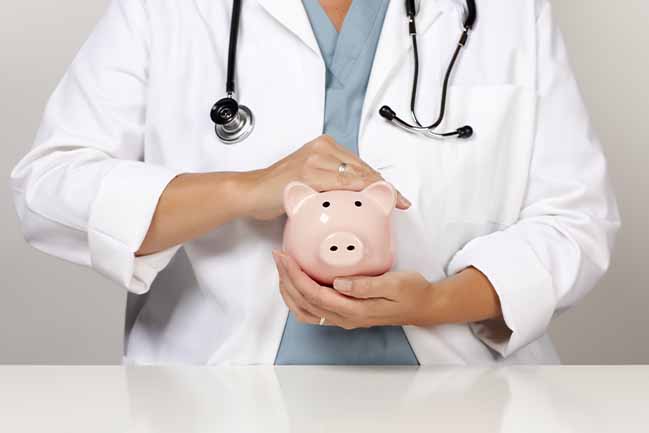 Medical student with stethoscope around their neck, holding a piggy bank