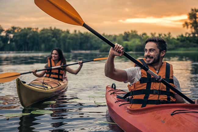 Happy students kayaking in a river.