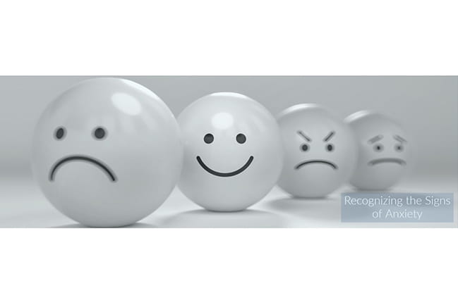 Recognizing the Signs of Anxiety written over photo of ping pong balls with different emotions drawn on them