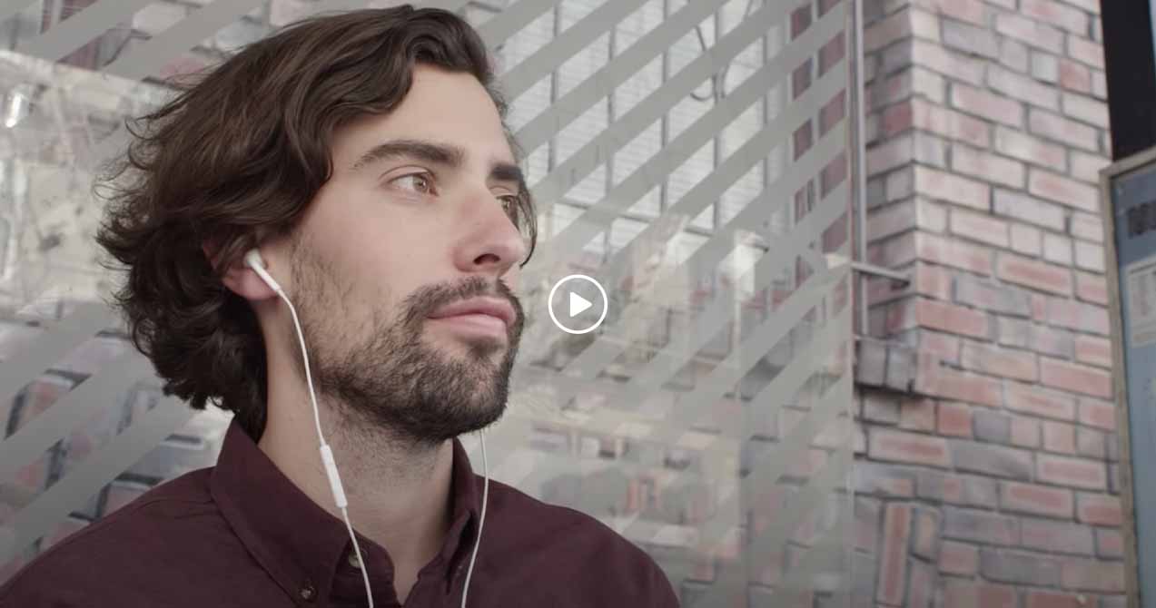 Man listening to music, gazing off into the distance.