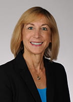 Dr. Rochelle F. Hanson is wearing a black and blue suite and is smiling at the camera.