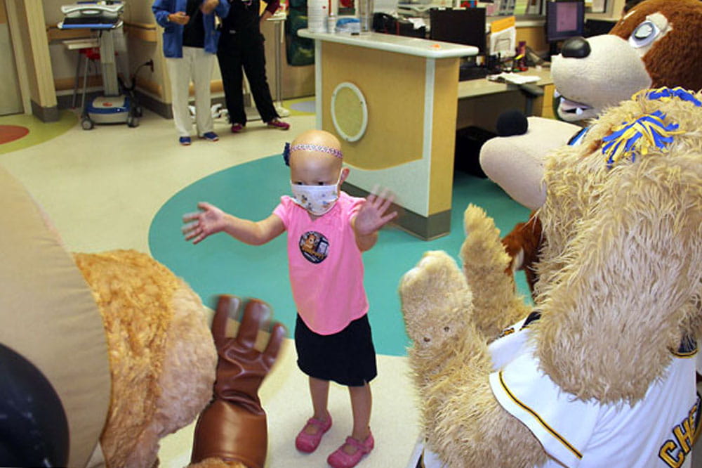 Abigail Lee gets waves and hugs from Charlie and Chelsea from the Charleston RiverDogs and Scrappy from Patriots Point at MUSC Children's Hospital. Photo by Allyson Crowell