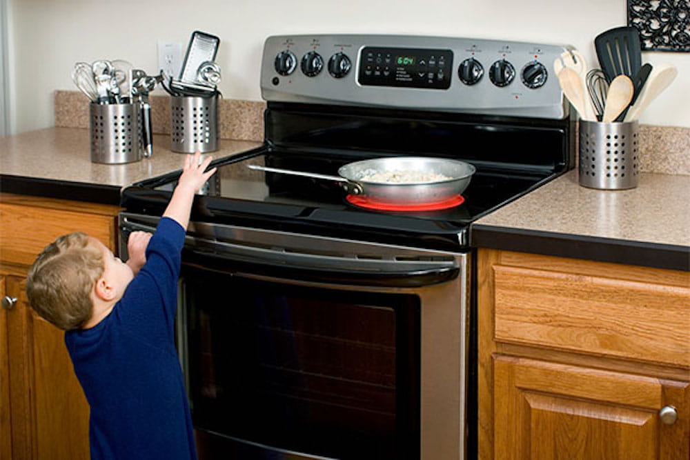 child reaching for a pan on hot stove