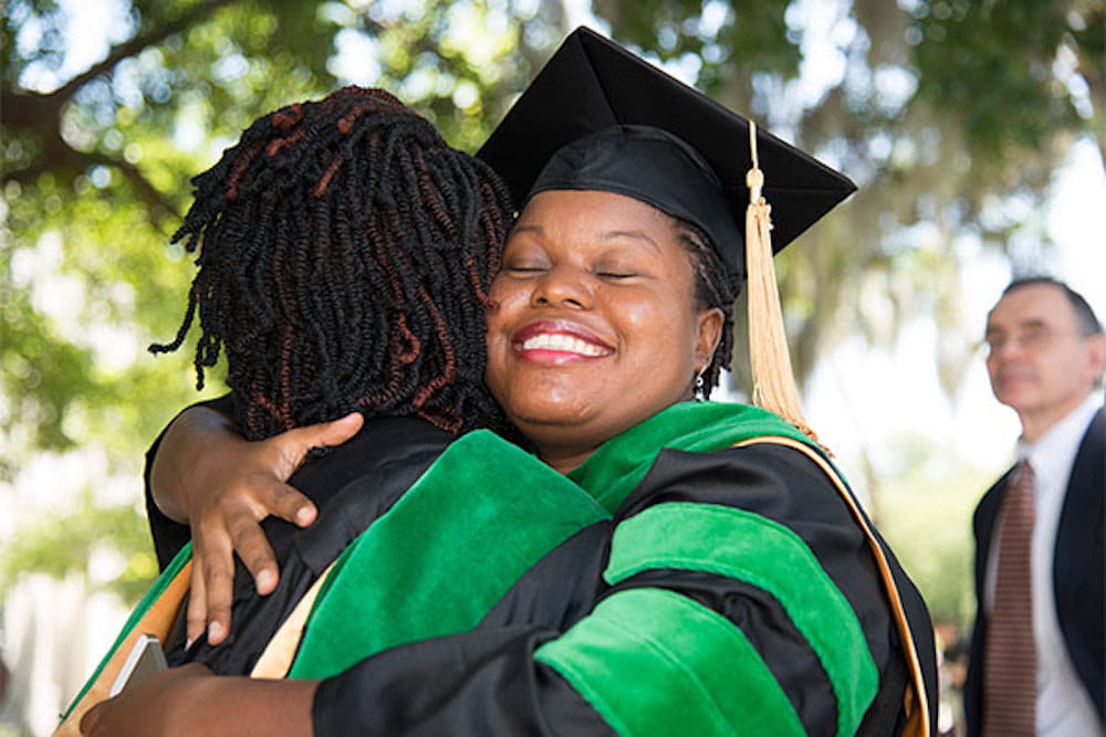 Two students hugging at graduation