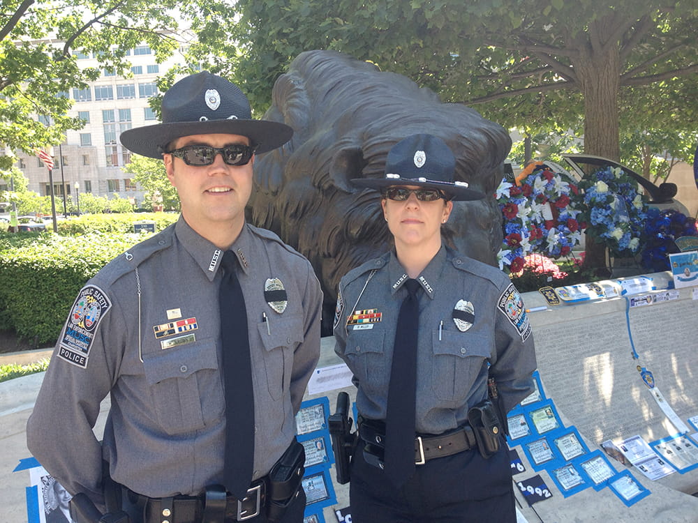 Two officers stand in front of a memorial 