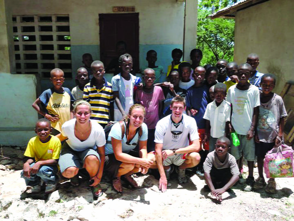 Group photo of three Americans with Haitian children