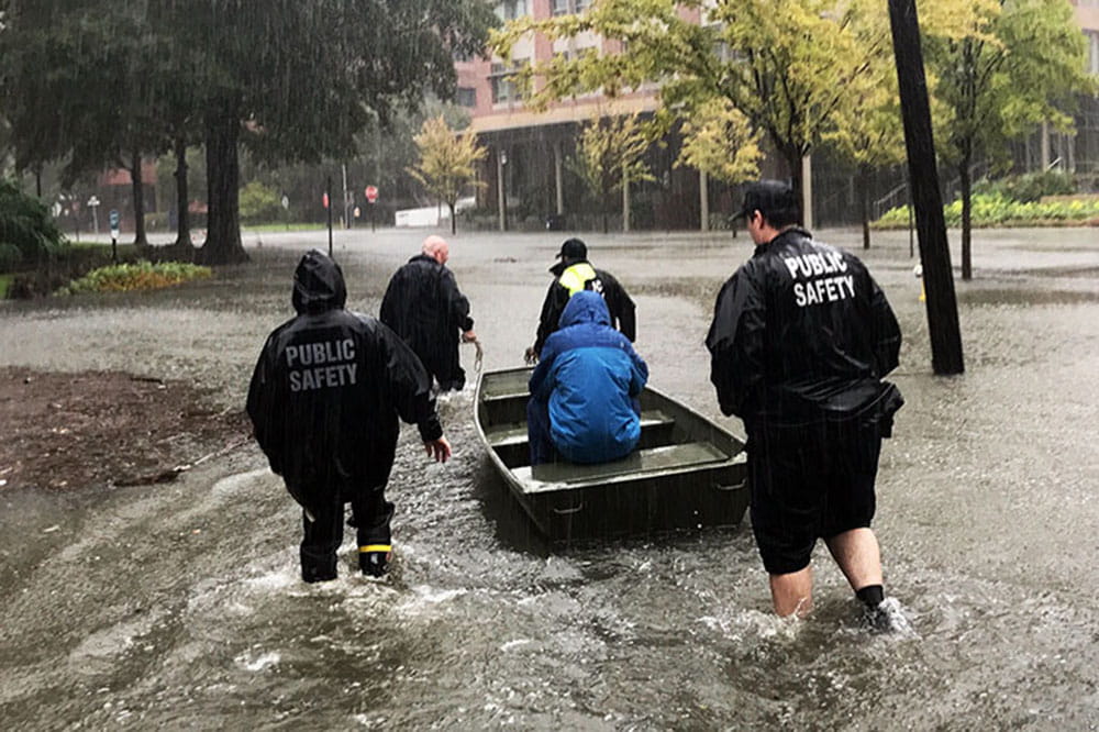Public safety officers pull employee through floodwater