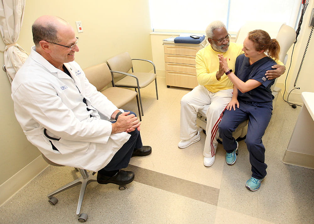 Dr. Marc Katz watches as James Gallant high-fives medical student Chelsea-Ann Patry. Gallant and Patry have a couple of things in common: Both have had heart problems and were treated by Katz. Photos by Sarah Pack