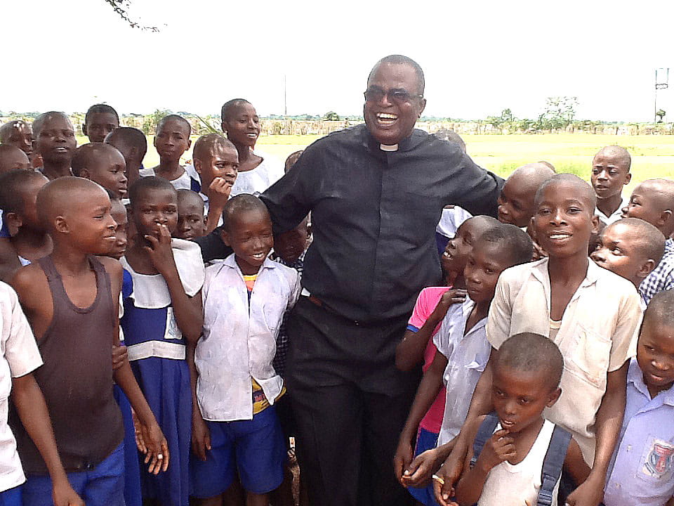 Father JohnBosco Ikemeh visits with public school children in a village in Nigeria. 