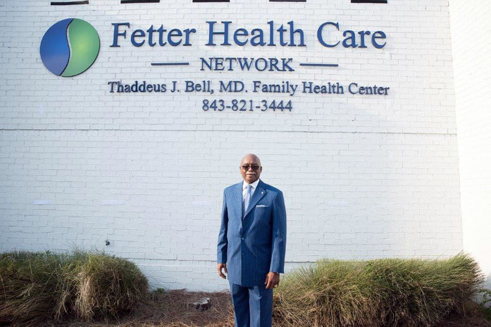 Thaddeus Bell, M.D., in front of the health center named in his honor.
