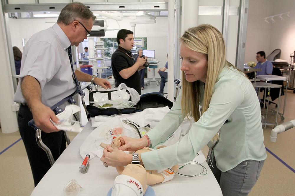 Participants prepare an infant mannequin for simulated surgery