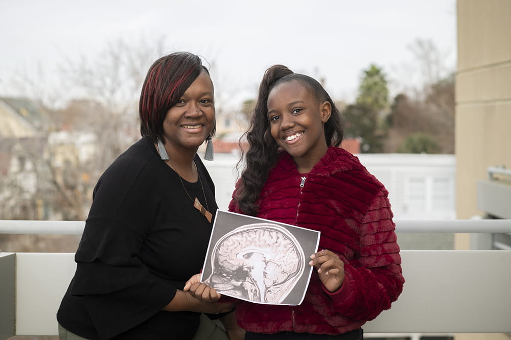 Tyra and Tyla Johnson with a printout of Tyla's brain scan
