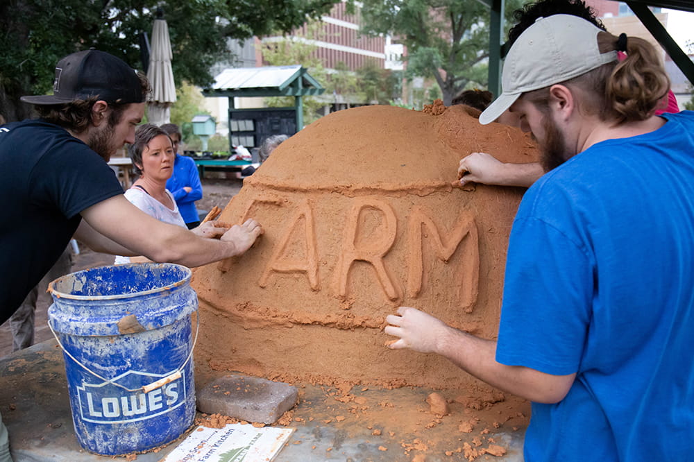 people write 'farm' in mud on the cob oven