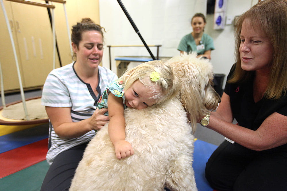 Macy is an MUSC therapy dog who is helping to calm MaryEllen Wilson.