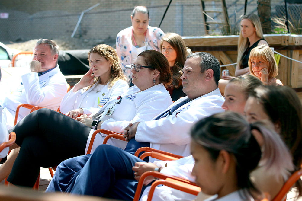 A crowd of onlookers, survivors and surgeons listens as Charlie Hanna speaks about his experience with trauma and how it shaped his life.