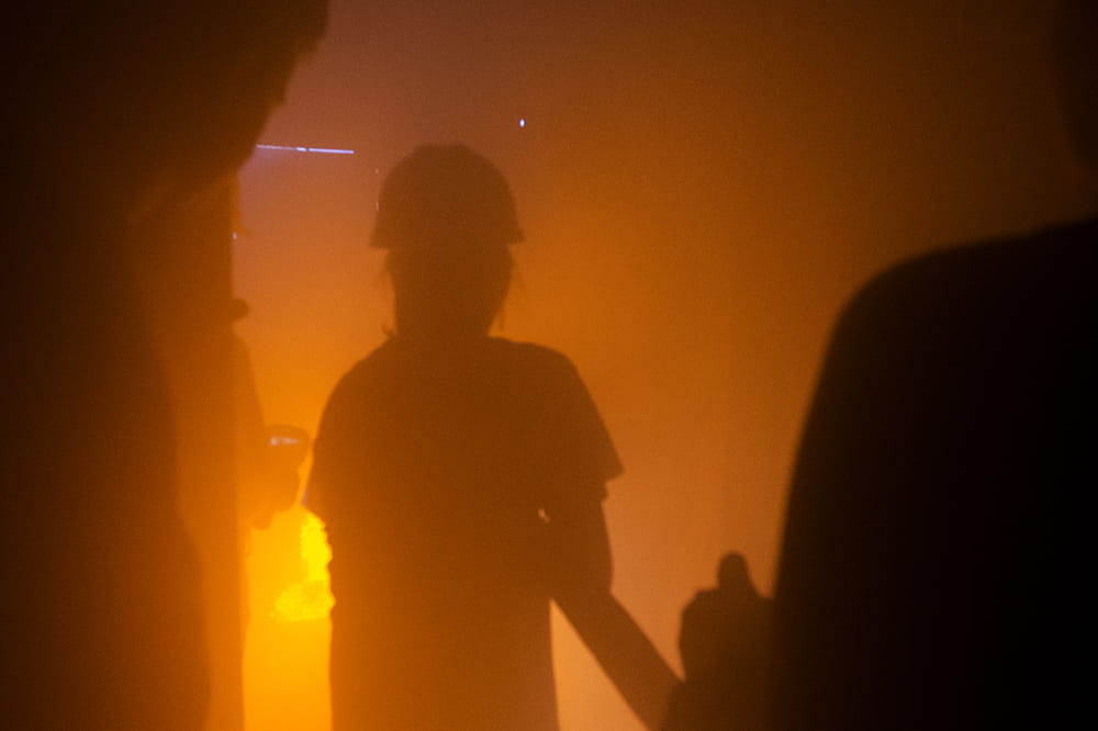 silhouette of person in glowing orange and red simulated fire room 