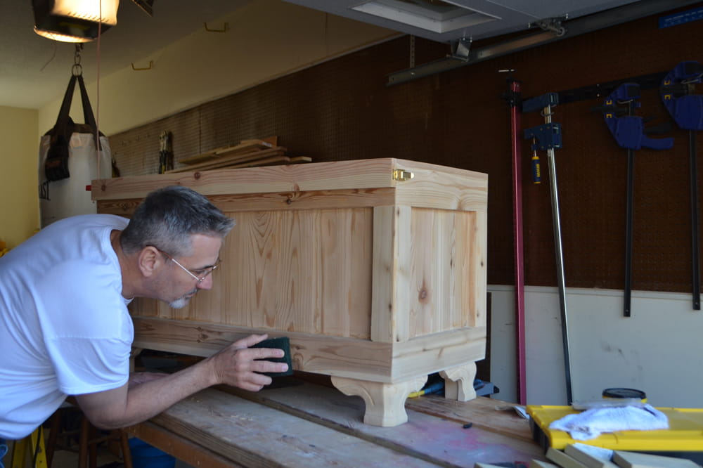 A man creates a wood chest by hand. 