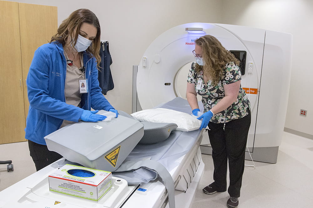 Erica Burns Radiologic Technologist, left and Donna Davis, Multi Modality CT Tech, clean equipment at West Ashley Medical Pavilion.