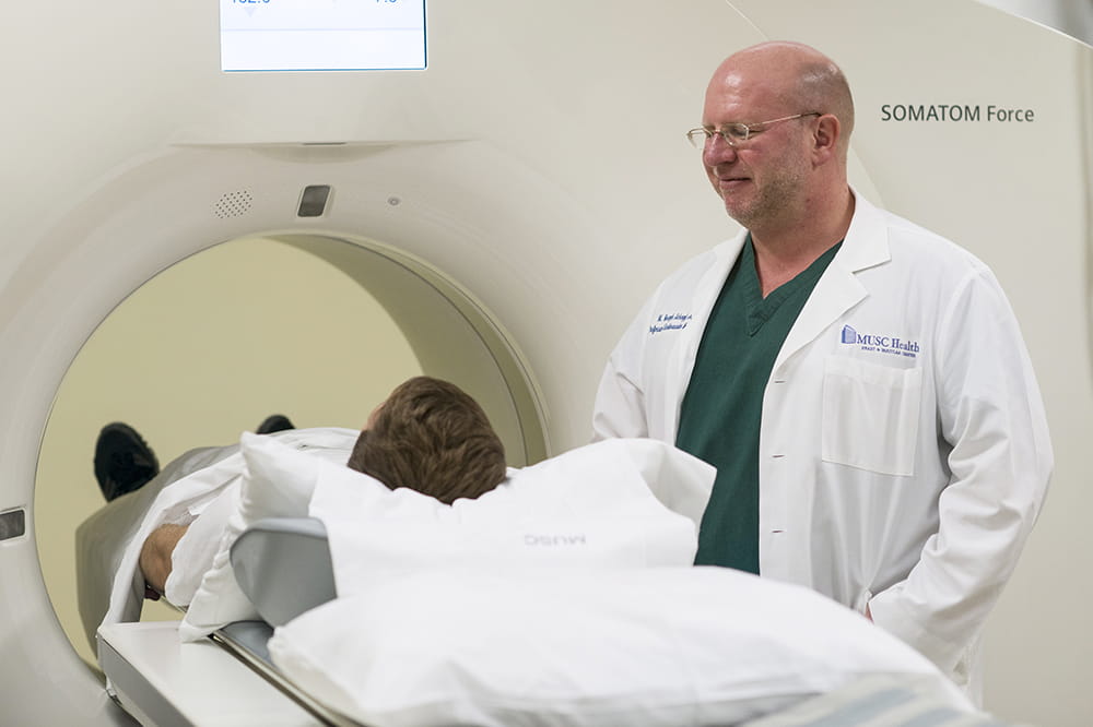 Dr. Schoepf watches as a patient enters a CT scanning machine
