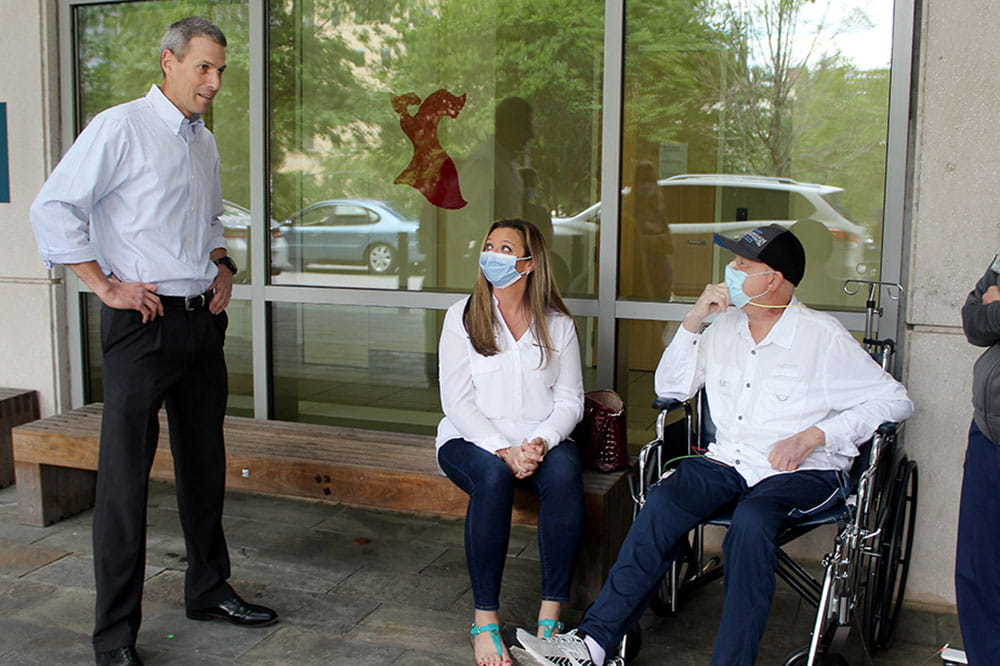 Surgeon Chadrick Denlinger catches up with John McDonald and his wife while making sure to socially distance by more than six feet from John. 