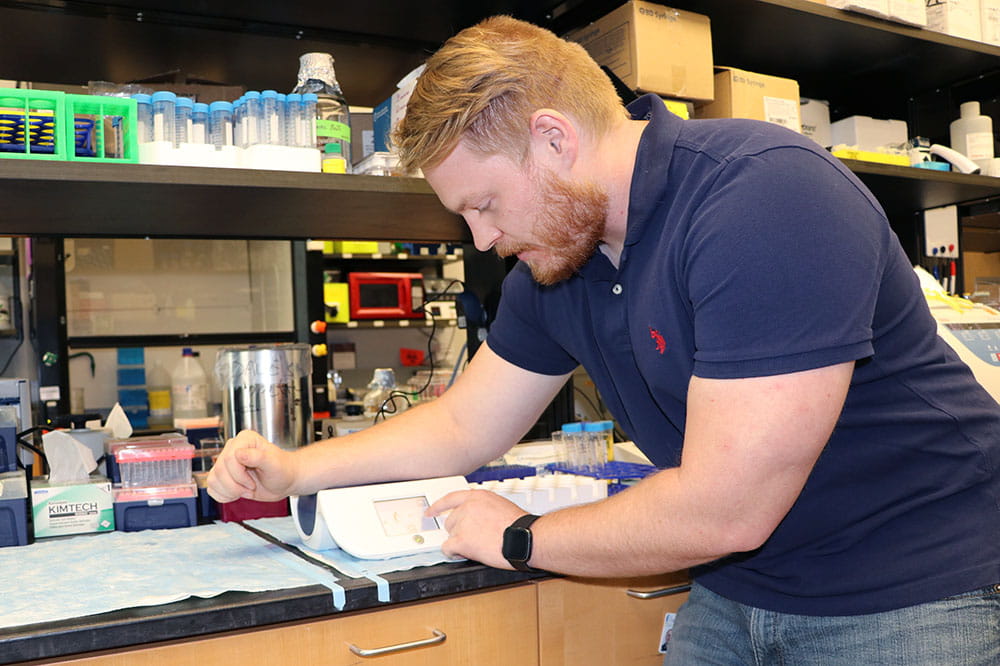 Bradley Krisanits demonstrates using the AGE reader in the lab