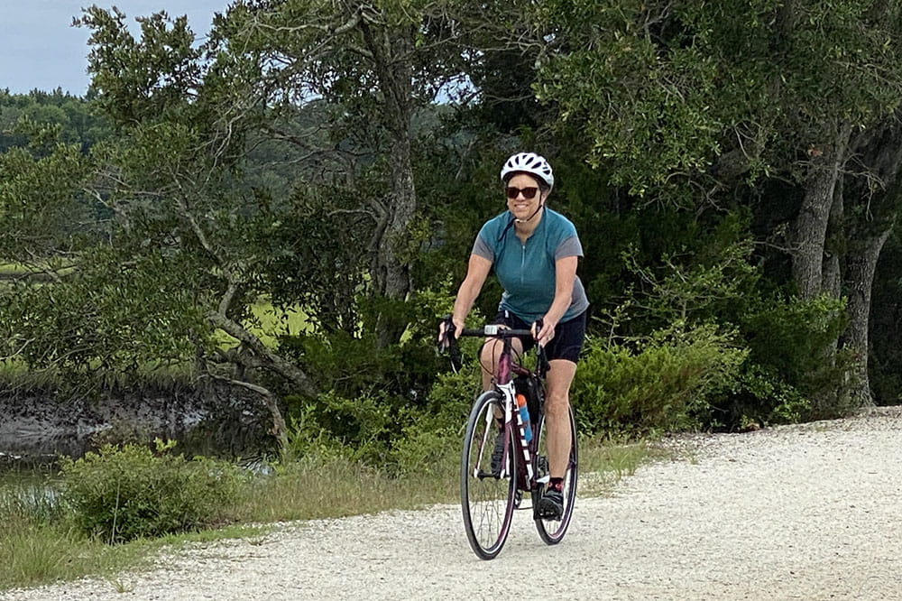 Kathy Hogan Edwards rides her bike on a nature trail