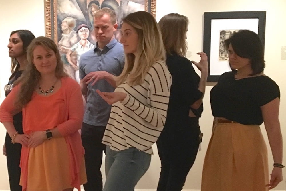 Health sciences students assuming poses of subjects depicted in works of art at the Gibbes Museum.