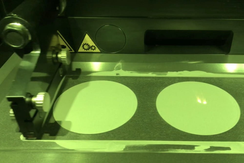 a 3D printer gives off an eerie green glow as it works