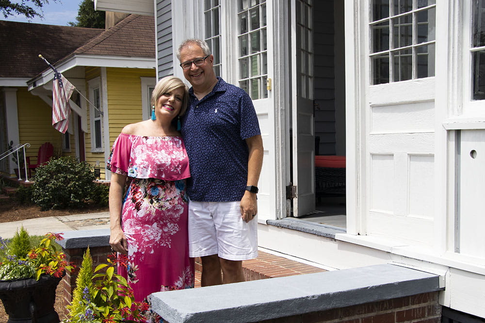 Jennifer and Mike Attisano stand on the steps in front of their house