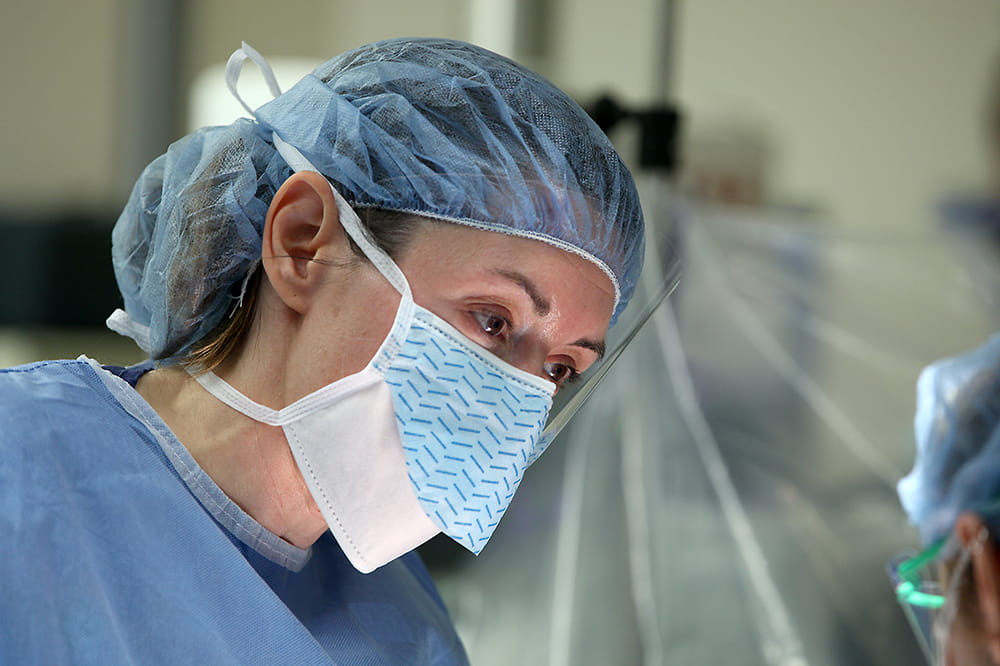 Dr. Heather Evans wearing a surgical cap and mask.