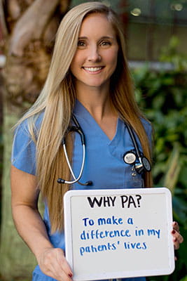 Sarah Lorick holds a sign that says why PA? To make a difference in my patients' lives