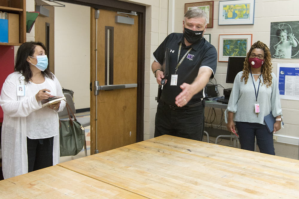 Charleston County School District Chief Operating Officer Jeff Borowy talks with MUSC Health nurse liaison manager Regina Fraiya and Simmons-Pinckney Middle School Principal Stephanie Spann in the summer before the 2020-2021 school year about pandemic precautions. Photo by Sarah Pack