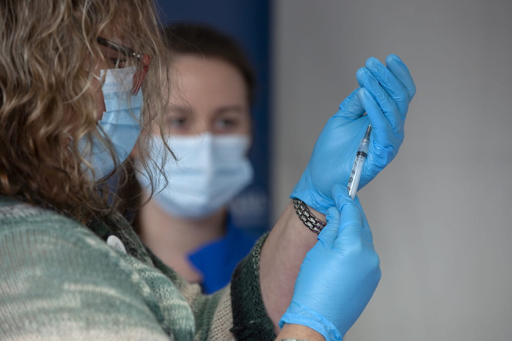Nurse filling syringe with Pfizer COVID vaccine