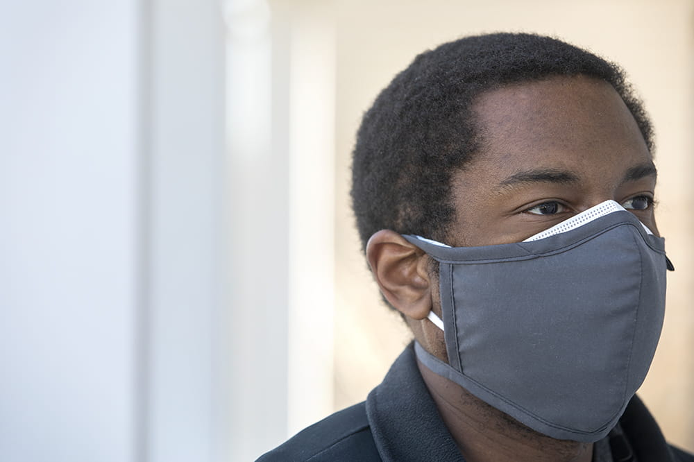 Closeup of man's face. He's wearing two masks to protect against the coronavirus.