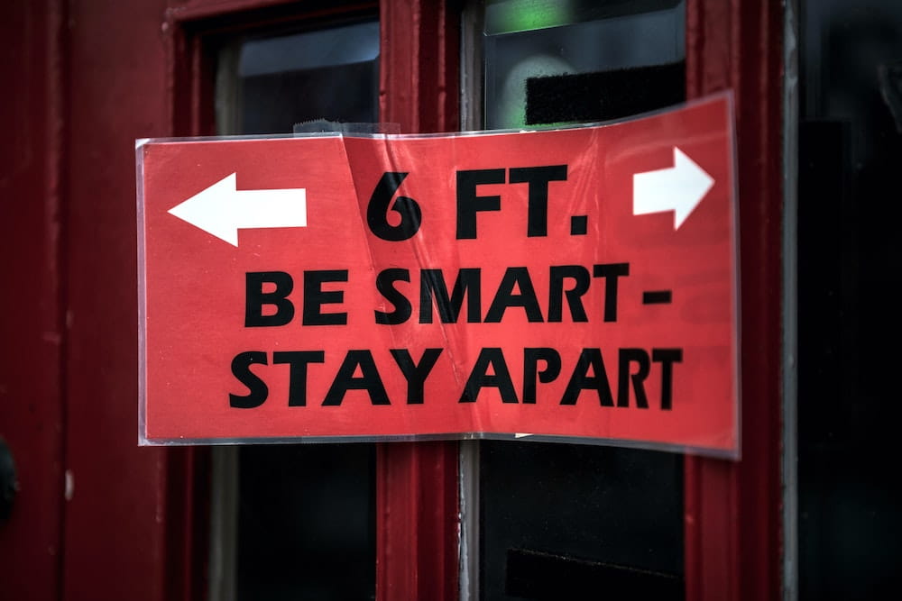 sign saying six feet, be smart, stay apart
